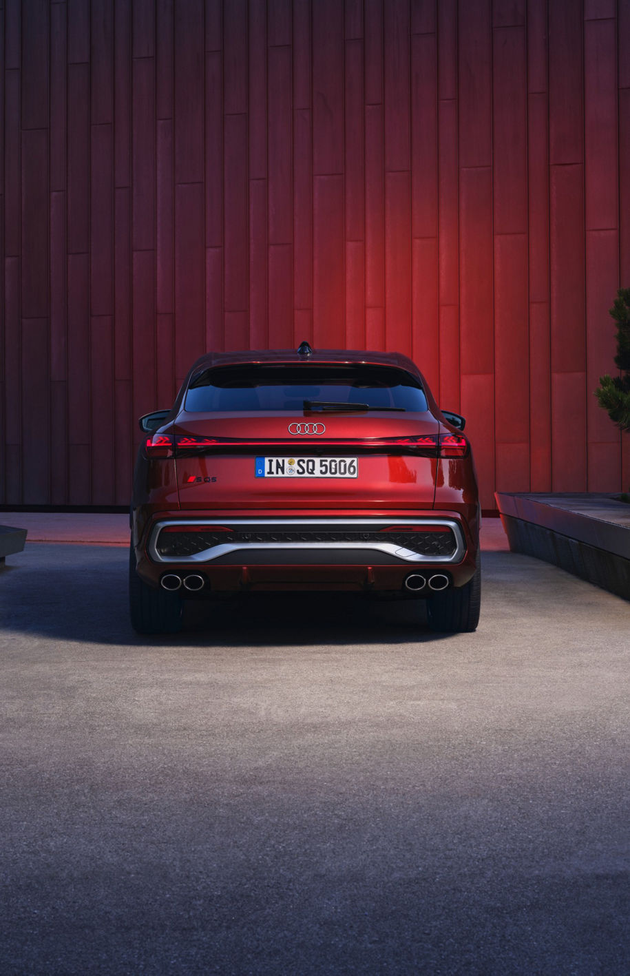 Rear view of an Audi car with a red wall background